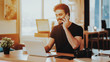 © VadimGuzhva - Happy Guy Talks Phone and Work on Laptop Remotely