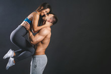 Happy Smiling Sporty Young Sexy Couple Isolated Over Black Background.