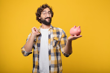 Wall Mural - young crazy mad man  fool pose with a piggy bank. savings concep