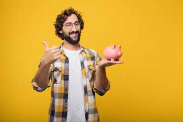 Wall Mural - young crazy mad man  fool pose with a piggy bank. savings concep