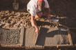 © Connect Images - Builder laying cement foundation