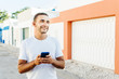 © F8  \ Suport Ukraine - Cheerful happy man typing sms while walking on the summer street