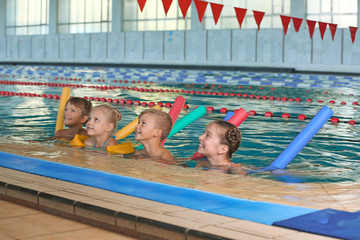 Wall Mural - Little kids with swimming noodles in indoor pool