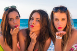 Fototapeta Młodzieżowe - Jovenes chicas sexys en la playa un dia de verano,  tirando besos.