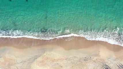 Wall Mural - Aerial view of a green coast with a beautiful wild beach bathed by a turquoise and transparent sea. Sardinia, Italy