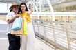 © livertoon - Asian attractive happy father and smile beautiful young daughter using her smartphone taking selfie between shopping on skywalk in metro station at shopping center or department store in holiday.