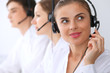 © rogerphoto - Call center operators at work. Focus at beautiful business woman in headset