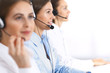 © rogerphoto - Call center. Group of operators at work. Focus on beautiful business woman in headset