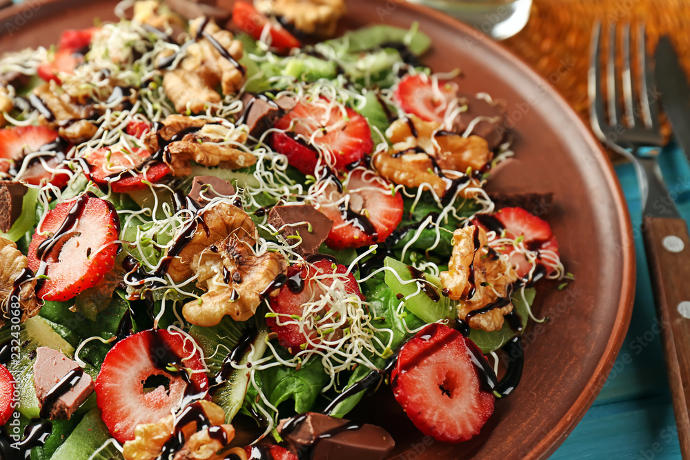 Delicious fresh salad with walnuts on plate, closeup