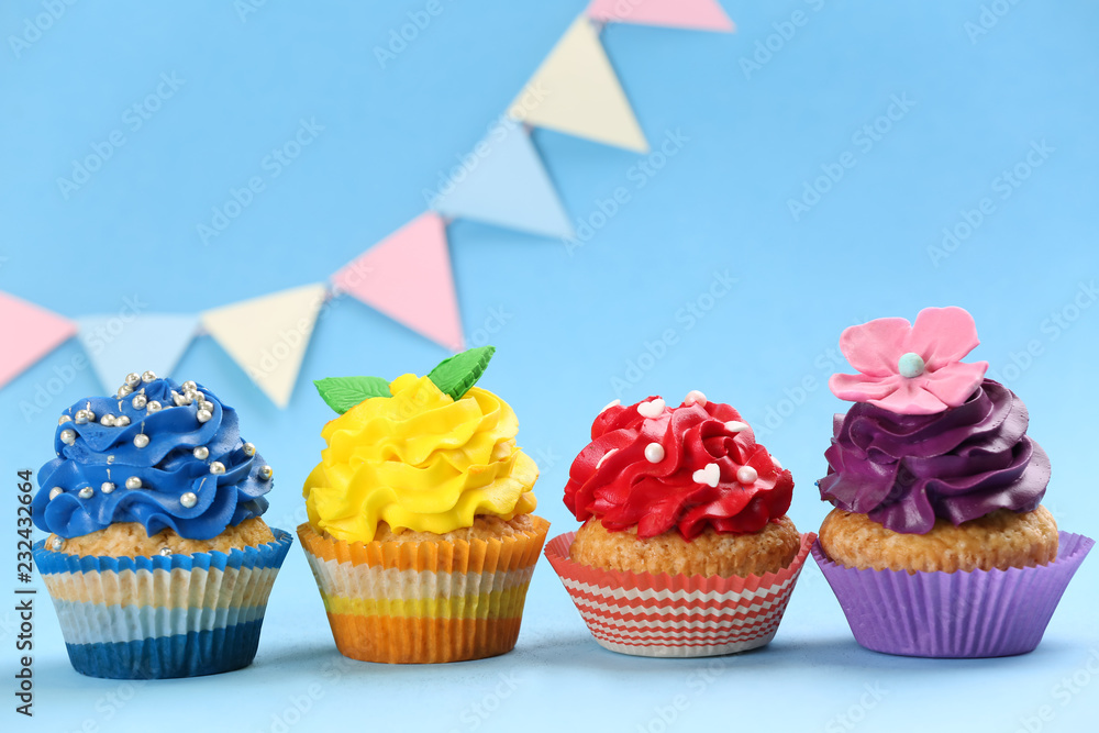 Tasty birthday cupcakes on color background