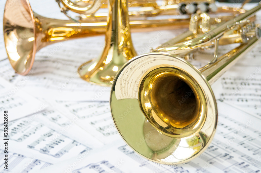 Three golden trumpet on sheet music - obrazy, fototapety, plakaty 