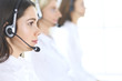 © rogerphoto - Group of call center operators at work. Focus on beautiful business woman in headset