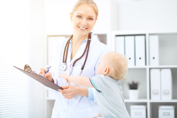 Doctor and patient in hospital. Little girl is being examined by pediatrician with stethoscope. Medicine and health care