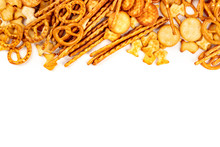 A Variety Of Salty Crackers, Sticks, Pretzels, And Goldfishes, Shot From The Top On A White Background With Copy Space. Party Snacks Mix With Copy Space