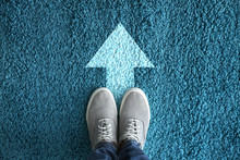 Man Standing On Carpet With Arrow Pointing In One Direction. Concept Of Choice