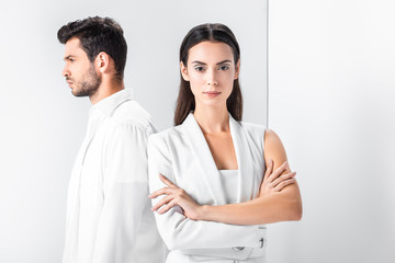 adult stylish woman in total white standing with arms crossed near man