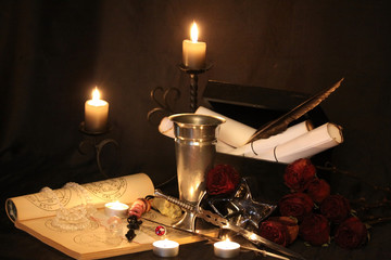 Antique Magic Book. Witchcraft Peacock feathers and candle background. Black candle Magic Ritual.