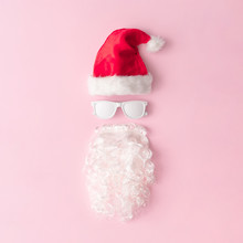 Santa Claus Portrait With Hipster Sunglasses On Pink Background With Copy Space. Minimal Flat Lay Christmas Theme. New Year Sale Concept.