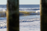 Fototapeta  - wave breaking along the shore by the pier