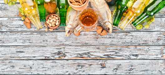 Wall Mural - Background beer and snacks. Hops, beer, chips, nuts. On a white wooden background. Free space for text. Top view.