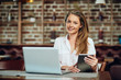 © chika_milan - Businesswoman using tablet while sitting in cafeteria. On table laptop.