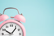 © TanyaJoy - Pink alarm clock on blue background