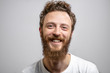 Portrait of young handsome softie, good-looking kind hipster man with beard smiling and looking at camera over white background with copyspace.