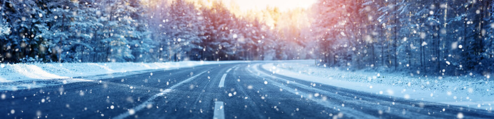 winter road, covered with snow on sunny day. Black icy asphalt