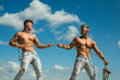 Force and power. Twins competitors with muscular bodies. Strong men pull rope with muscular hand strength. Men shows off their strength against competitors. Athletic twins on opposite sides