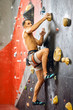 © alfa27 - Caucasian athlete climber man with bare body exercising on grey practical wall with footholds, indoor shot, bouldering, profile full-size shot.