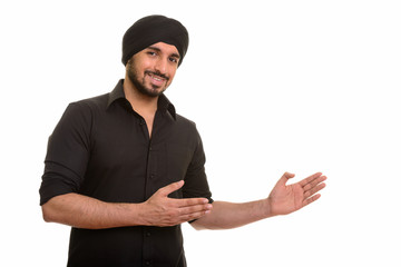 Wall Mural - Portrait of young happy Indian Sikh man showing something