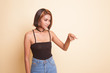 © halfbottle - Beautiful young Asian woman point down to blank space.