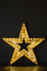 Wall Mural - The wooden star with light. Under a black background.