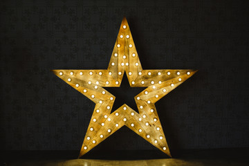 Wall Mural - the wooden star with light. under a black background.