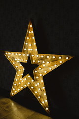 Wall Mural - the wooden star with light. under a black background.