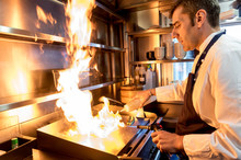 Man Cooking In Bright Flame