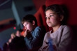 © Stocksy - Children watching a movie in a movie theatre