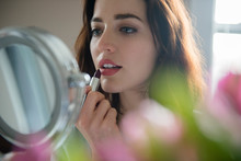 Woman Applying Lipstick In Mirror