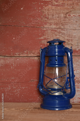 A Blue Camping Lantern On Red Barn Board Buy This Stock Photo