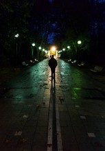 Man Walking Alone Throug A Dark Street At Night