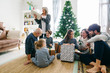 © Stocksy - Family opening gifts for Christmas. Family wearing pajama celebrating Christmas at home.