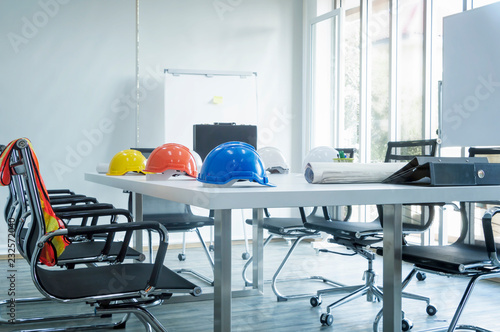 Fotografía Colorful helmet and file folder on white table in meeting room.