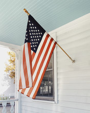 American Flag On A White Front Porch In America