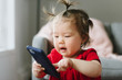 © Stocksy - Baby looking at cell phone