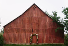 Wedding Arbor In Front Of Rustic Red Barn