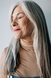 © Stocksy - Portrait of a smiling senior woman with grey long hair.