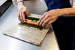 © Stocksy - Close-up of chef rolling sushi