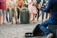 Street Musician Playing Guitar On City Street In Summer