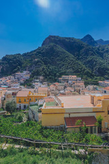 Houses of the town of Amalfi, Italy, under mountains and blue sky