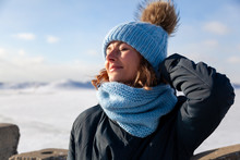 Portrait Beauty Woman Model On Winter Background. Beautiful Modern  Young Woman Wearing Blue Knitting Hat  Warm Hands, Smile, Look At Camera On A Walk On The Frozen Sea In Winter